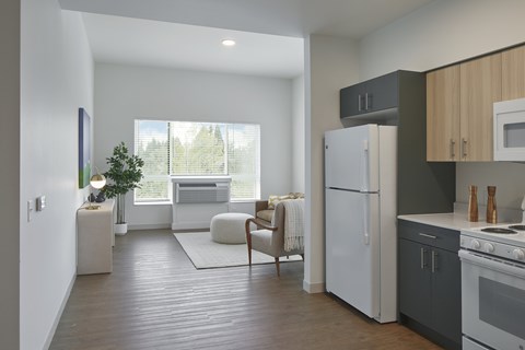 A modern kitchen with a refrigerator, oven, and a dining table with chairs.